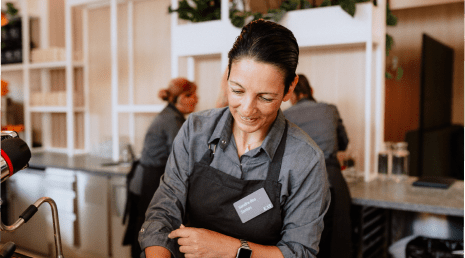 Mitarbeiterin bereitet Kaffee zu