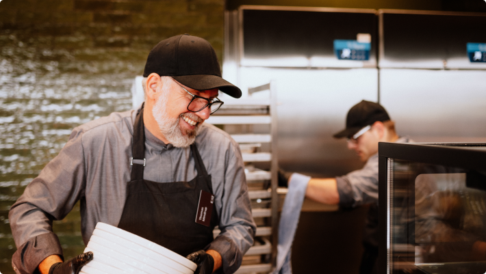 Kollegen stehen zusammen in der Küche und bereiten Mittagessen vor