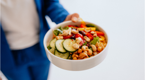 Person mit blauem Anzug hält eine Bowl in die Kamera